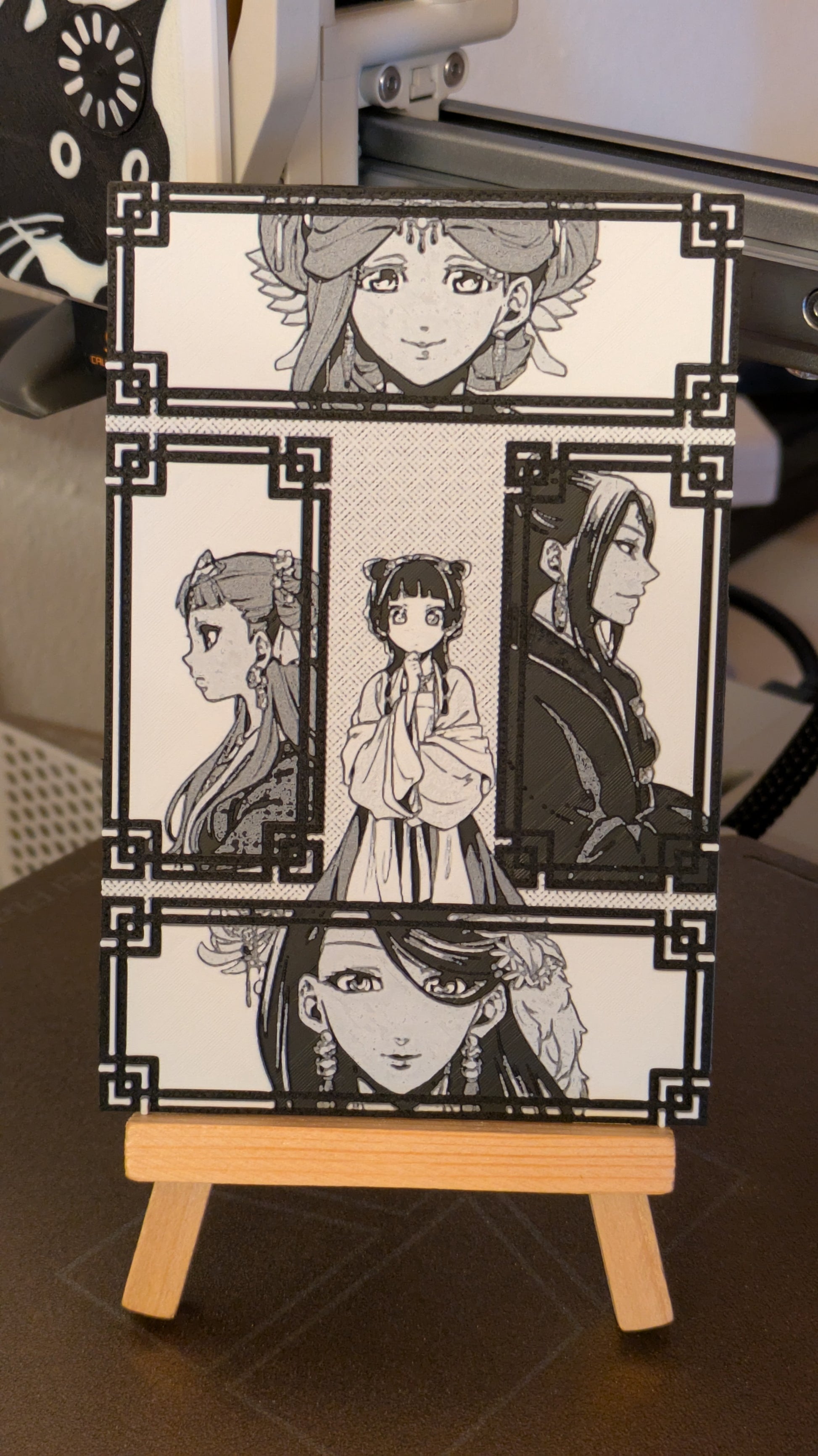 Apothecary Diaries magnet panel featuring 5 characters with decorative frames, 3D printed manga collectible displayed on wooden easel